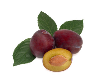 Three plums with plum leaves on a white background.