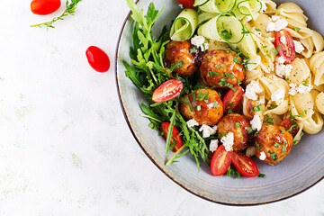 Italian pasta. Conchiglie with meatballs, feta cheese and salad on light background. Dinner. Top view, overhead. Slow food concept