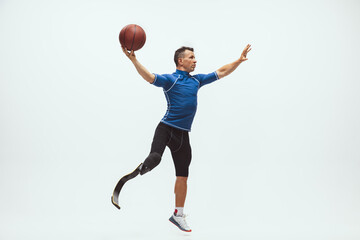 Athlete with disabilities or amputee on white studio background. Professional male basketball...