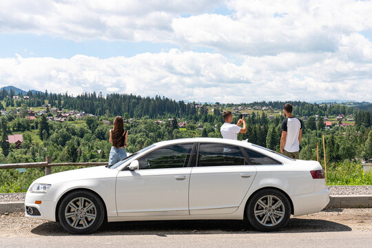 Freedom Of Car Travel. Car With Three Friends At The Top Of The Hill With Beautiful View On Mountains