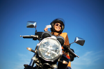 Motorcycle riding school and courses. Student with helmet and reflective vest riding motorcycle on...