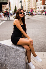 Fototapeta premium Young hispanic woman posing on a summer day while strolling through a square