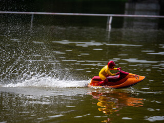 RC controlled jet ski model on lake. Active summer vacation for school child.