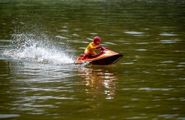 RC controlled jet ski model on lake. Active summer vacation for school child.