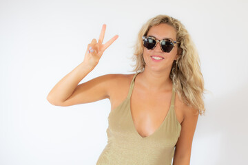Naklejka premium Pretty smiling blonde woman with sunglasses in golden swimsuit