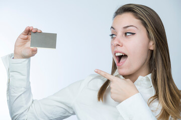 ragazza bionda con camicia bianca tiene in mano una tessera sconti che indica, isolata su sfondo...