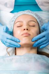 A young girl is cleaning the skin of her face at a cosmetologist. Facial cleansing and massage