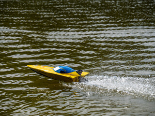RC controlled speedboat model on lake. Active summer vacation for school child.