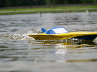 RC controlled speedboat model on lake. Active summer vacation for school child.