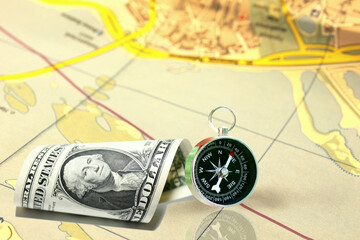 Classic round compass and one hundred dollars on old paper map as symbol of tourism with compass, travel with compass and outdoor activities with compass
