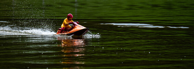 RC controlled jet ski model on lake.
