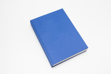 Blue book with no title standing on white background