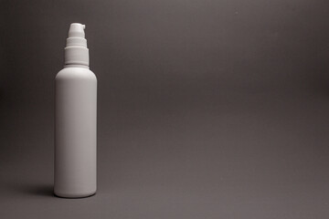 white hand sanitizer spray bottle on gray background.