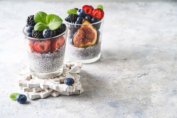Healthy chia pudding with strawberries, blackberries, blueberries and figs served in a glass