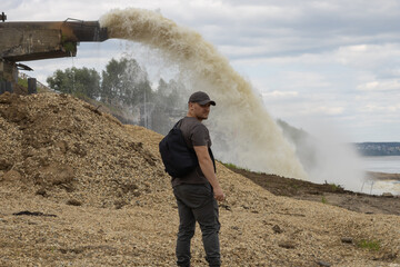 Obraz premium A man on the background of a spillway from an industrial plant.
