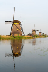 Windmills by canal at Kinderdijk, Netherlands, with reflection