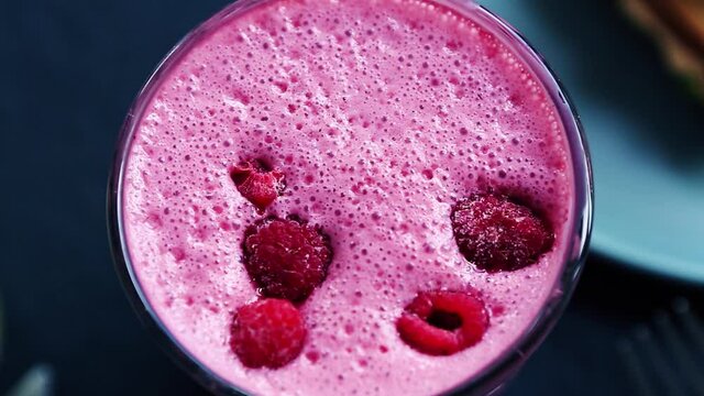 Raspberry cocktail with fresh berries filmed in close up.Video clip of fresh cold beverage with natural ingredients for healthy nutrition.Enjoy refreshing beverage in hot summer day