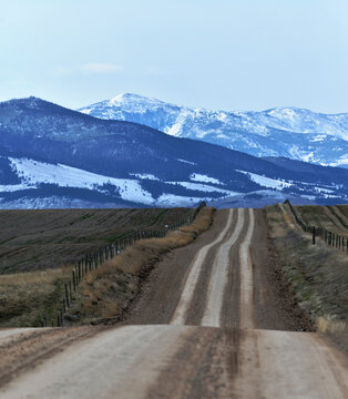 Rural road points toward the distant Elkhorn mountains in western Montana.