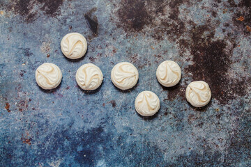 White marshmallows with coffee on a blue metal background..Free space for text.Top view.Holiday and festive food concept