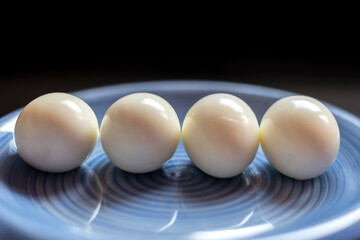 Hard boiled eggs on blue plate and dark background