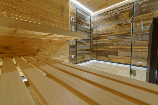 Moderne Sauna in geschroppter Zirbe mit Alttholz-Vorraum, Glasfront und kubischem Saunaofen