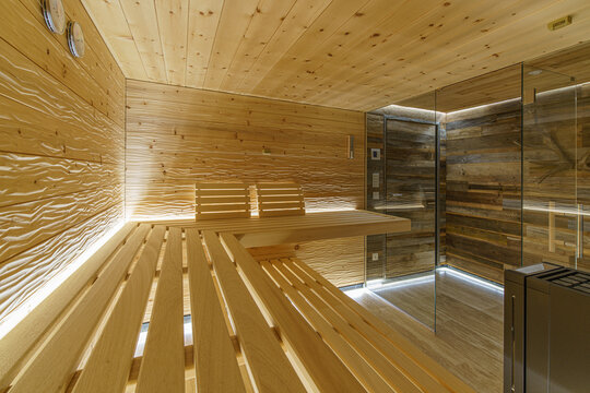Moderne Sauna in geschroppter Zirbe mit Alttholz-Vorraum, Glasfront und kubischem Saunaofen
