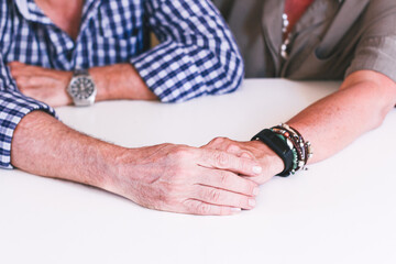 Older couple's hands caressing each other.