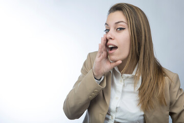 Manager donna bionda in giacca beige chiama qualcuno portando la mano alla bocca,  isolata su sfondo bianco