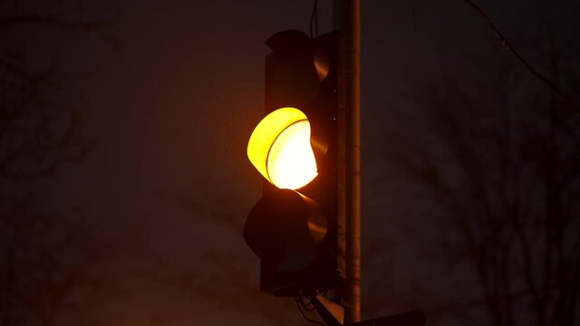 Red yellow green traffic light at night city street closeup.