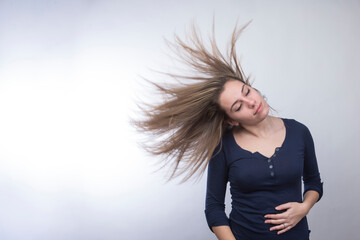 ragazza bionda vestita casual balla divertita e tira capelli cielo , isolata su sfondo bianco