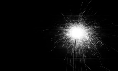 Obraz premium Bengal fire lights. Festive new year background. Festival and birthday party. Christmas Bengal Lights. Copy space. Winter holidays. Black and white photo.