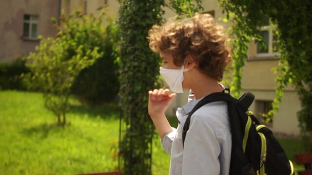 Contactless greeting. Masked schoolchildren comply with safety rules during quarantine of coronavirus covid-19. Children disinfect their hands and greet non-contact