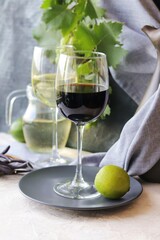 
Glass with young wine, a bunch of grapes on a gray background, on the table, summer season, home cooking