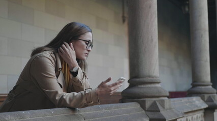 Obraz premium Student reading bad news on phone. Businesswoman using smartphone outdoors