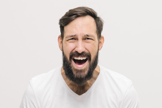  close-up portrait of screaming Young man over white isolated background . High quality photo