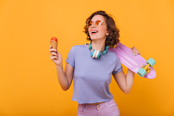 Adorable white girl with ice cream expressing happiness. Indoor portrait of spectacular lady with...