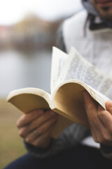 A man is reading a book in the park. Enjoyable rest in the park. Book reading.