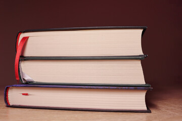 Stack of books (three) on the table. Education and learning. Dark background. Close up view.