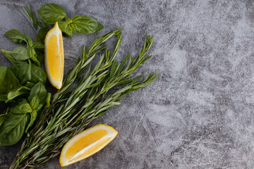 Selection of herbs and spices on stone background. Rosemary, basil and lemon with copy space. Top view