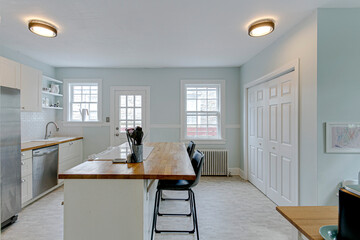 Modern white kitchen baby blue wall paint butcher block island luxury white stove stainless steel bar stool