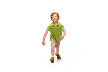 Happy child, little and emotional caucasian boy jumping and running isolated on white background. Looks happy, cheerful, sincere. Copyspace for ad. Childhood, education, happiness concept.