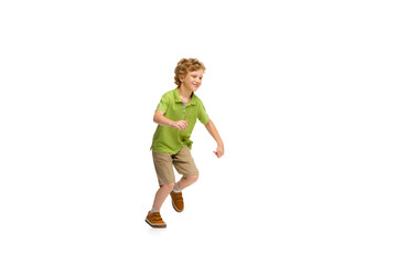 Happy child, little and emotional caucasian boy jumping and running isolated on white background. Looks happy, cheerful, sincere. Copyspace for ad. Childhood, education, happiness concept.