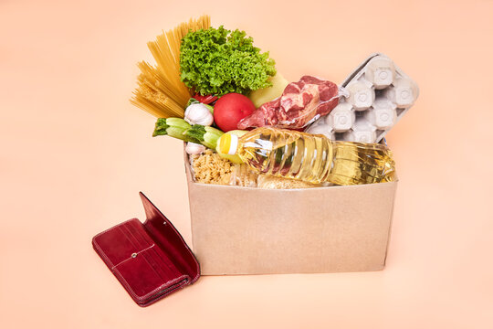 Various fresh products, pasta, cereals, meat and herbs are stored in a cardboard box. Concept of food delivery, humanitarian aid, contactless delivery from the store.