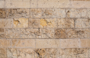 Textured stone wall close-up. The background. Limestone.