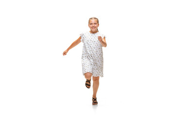 Happy child, little and emotional caucasian girl jumping and running isolated on white background. Looks happy, cheerful, sincere. Copyspace for ad. Childhood, education, happiness concept.