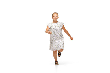 Happy child, little and emotional caucasian girl jumping and running isolated on white background. Looks happy, cheerful, sincere. Copyspace for ad. Childhood, education, happiness concept.
