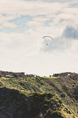 Paraglider over hills of Bay of Islands, New Zealand