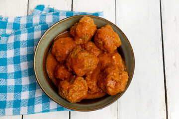 Meatballs in red sauce on white background