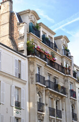 Fototapeta na wymiar Facade & Iron Balconies on Old Residential Building against Blue Sky
