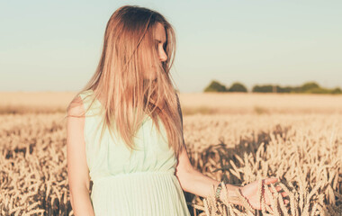 
a woman walking in a wheat field